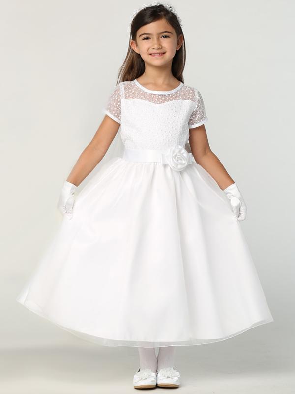 A girl wearing a brand-new white communion dress with a tiara